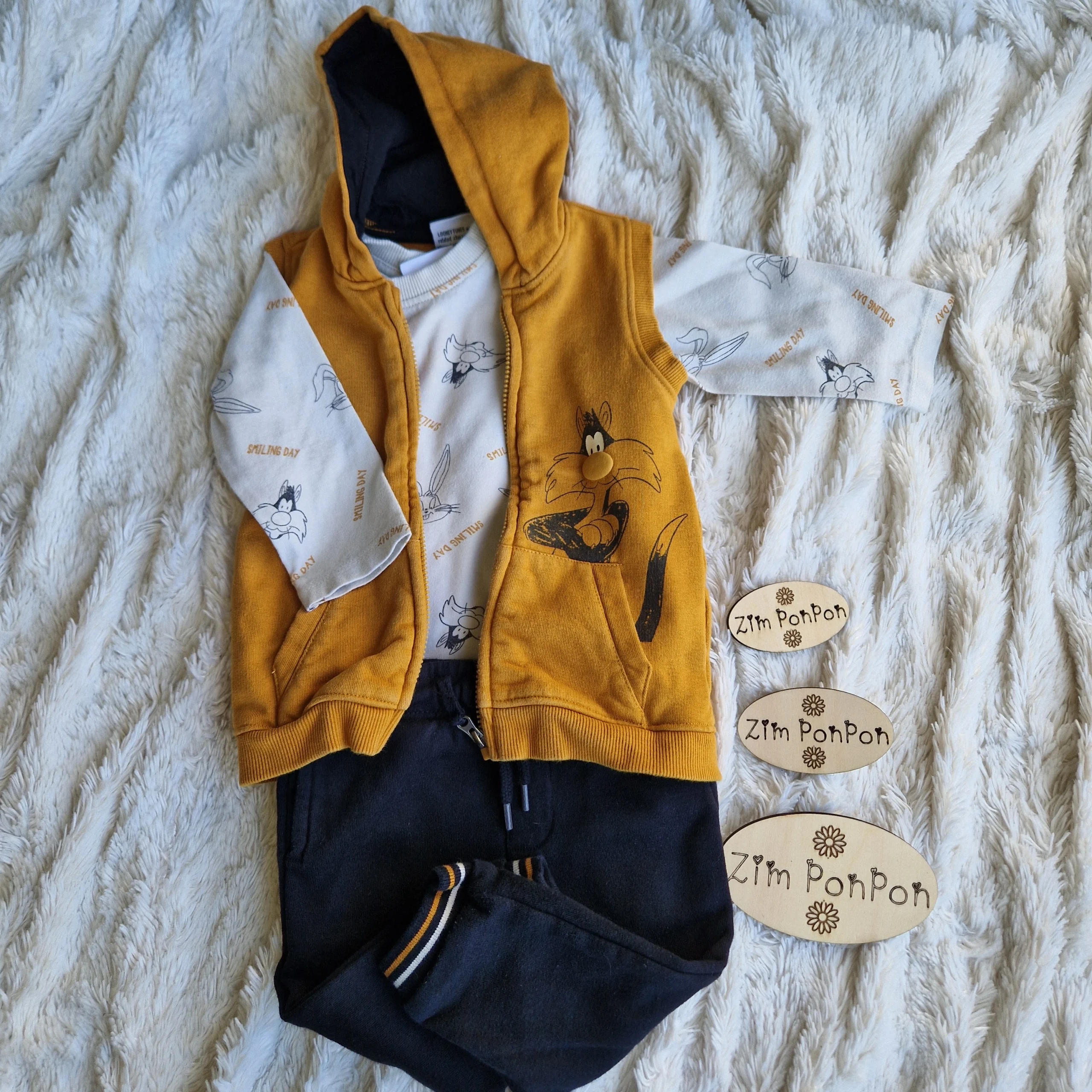 lot winnie 9 mois ensemble 3 pièces looney toons un tee shirt blanc cassé une veste sans manche a capuche orange et un pantalon décontracté noir